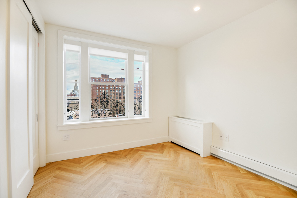a living room with a large window and a wooden floor